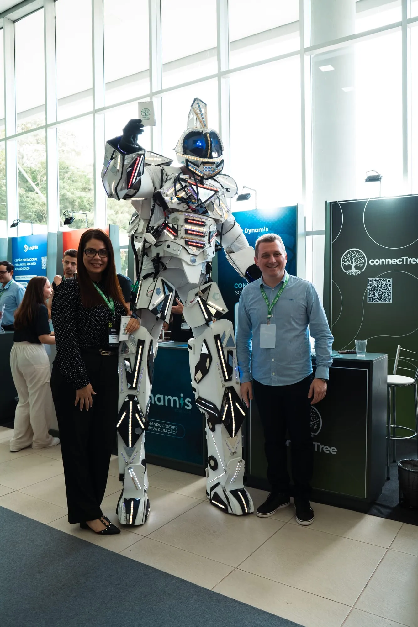 Participantes posam com robô de LED no espaço de exposição